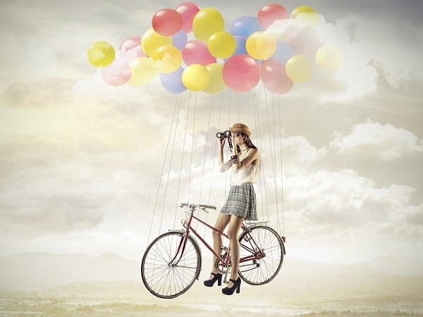 Chica bicicleta globos volar