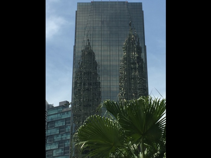 Viajar a Malasia: Reflejo Torres Petronas en edificio cristal, Kuala Lumpur